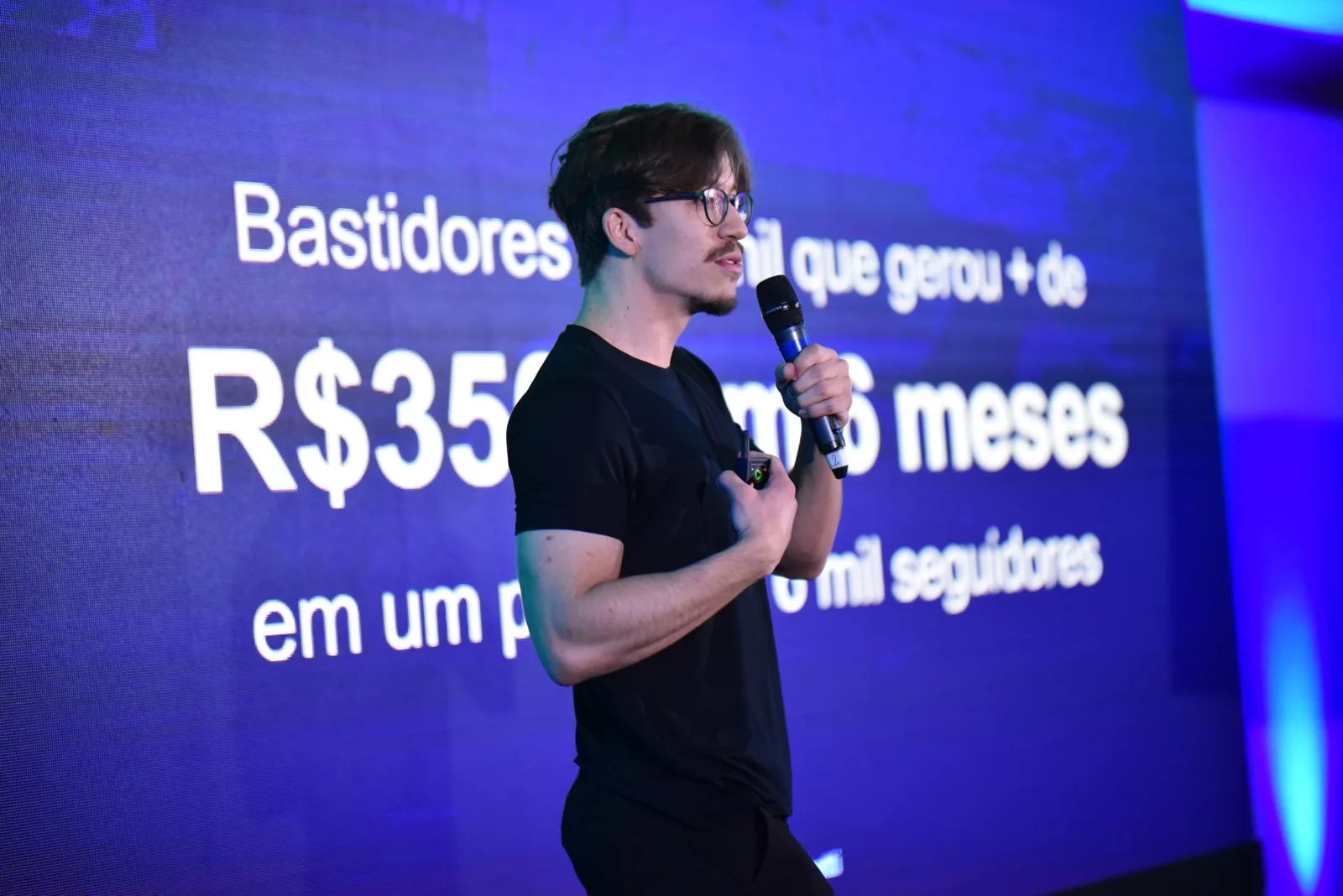 Arthur Pasetti no palco, com o telão ao fundo